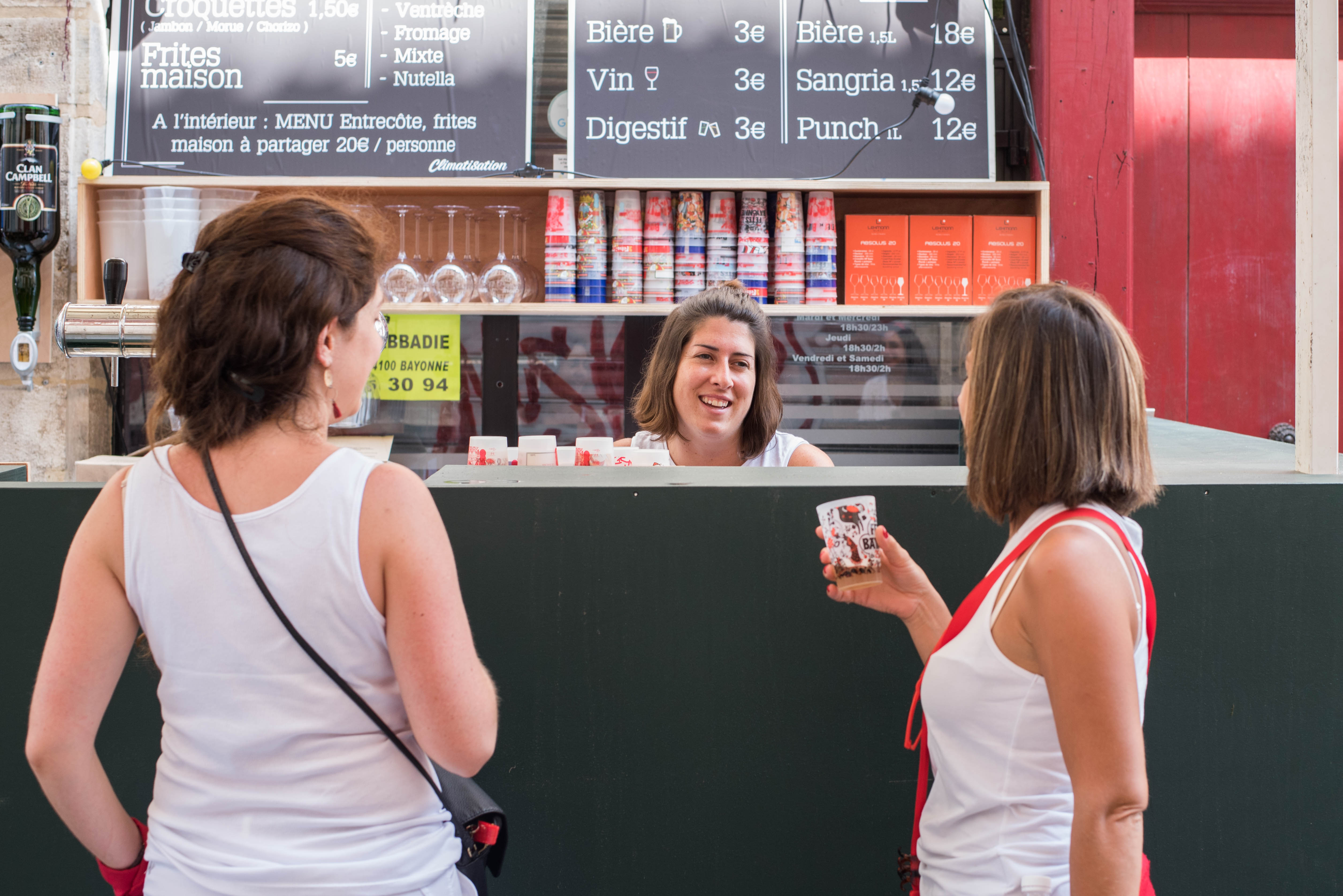 Two young people in front of a refreshment stand with personalized premium cups
